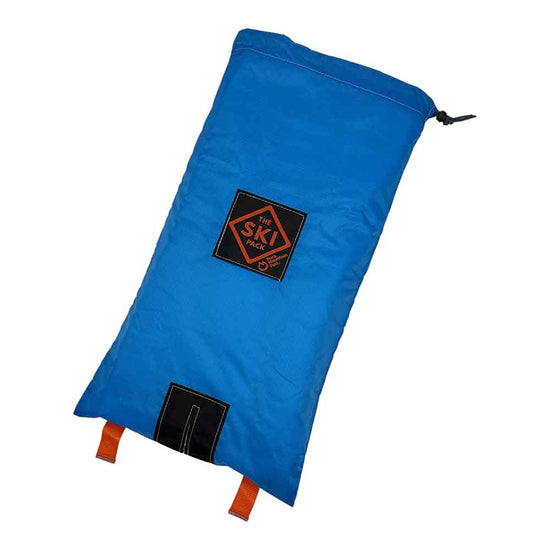 A blue ski bag with a black logo patch reading 'The Ski Pack' and orange straps, shown on a plain white background.