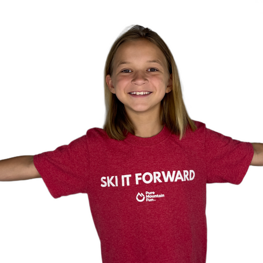 Child wearing a red 'Ski It Forward' t-shirt on a white background
