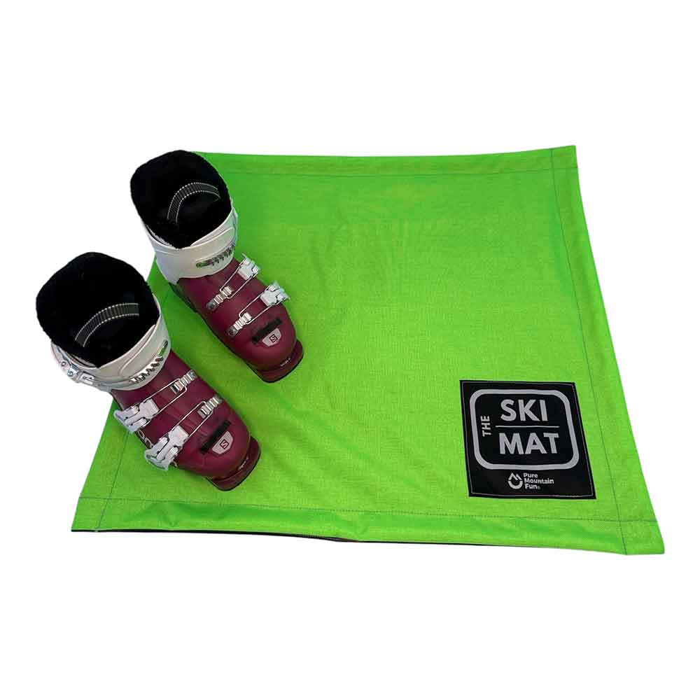 Green ski mat with ski boots on a white background