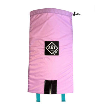 A light pink ski backpack by The Ski Pack, featuring a black diamond-shaped logo patch in the center and a black zipper closure at the bottom, shown against a plain white background.