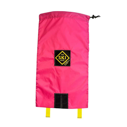 A bright pink ski boot bag with a black logo patch reading 'The Ski Pack' and yellow drawcord ties, shown against a plain white background.