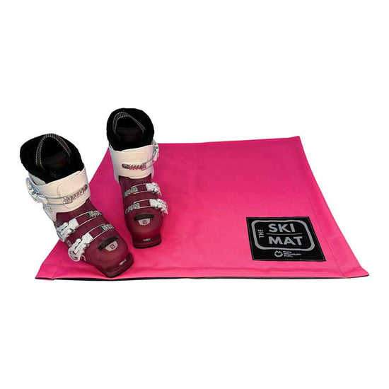 Pink ski mat with ski boots on a white background