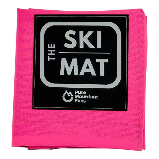 A folded hot pink ski mat with a black square patch featuring the text 'THE SKI MAT' in white and 'Pure Mountain Fun.' below it, shown on a plain white background.