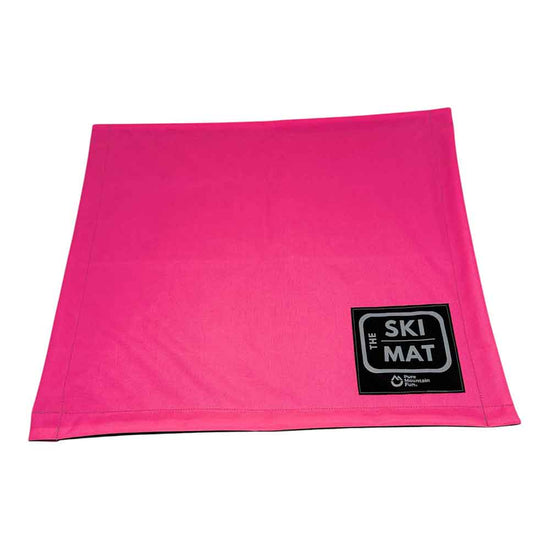 A bright pink rectangular ski mat with a black and white 'THE SKI MAT' logo patch in the bottom right corner, shown on a plain white background.