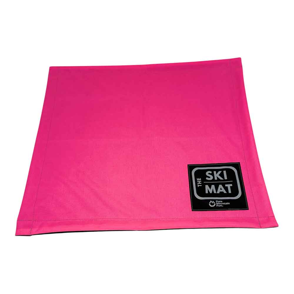 A bright pink rectangular ski mat with a black and white 'THE SKI MAT' logo patch in the bottom right corner, shown on a plain white background.