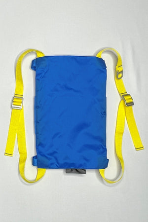 Back image of the blue Rider Pack which features blue ripstop fabric with yellow straps. Strap adjusters and a d-ring are included. 